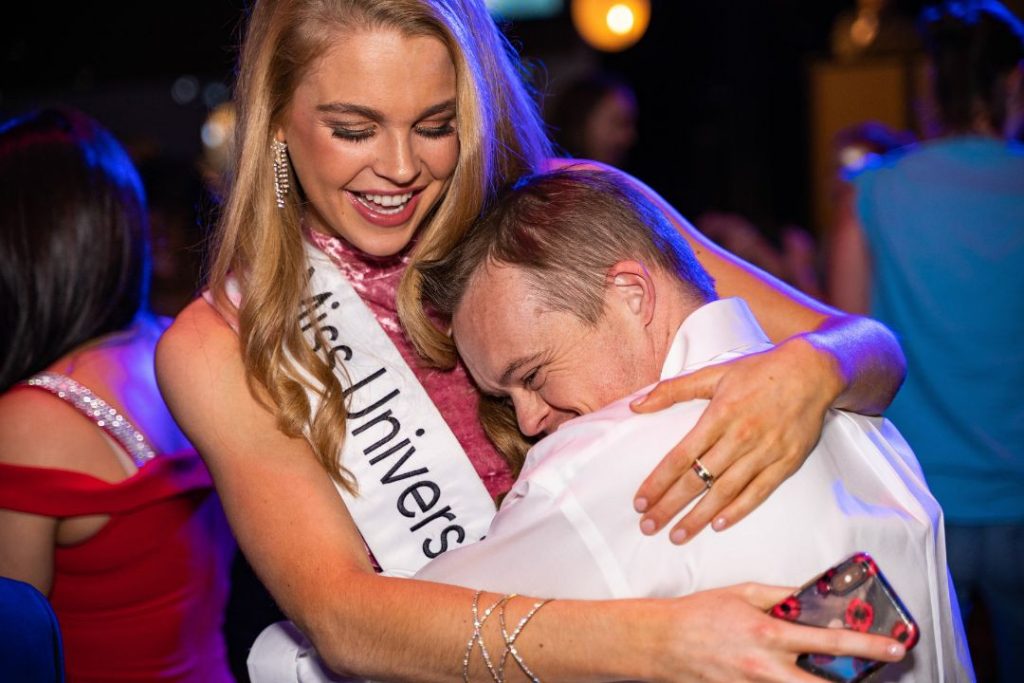 Fotografía de miss universo abrazando a un fan cuando Trump