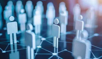 Figuras de madera con forma humana se encuentran sobre una superficie oscura conectadas por líneas de red blancas, que representan conexiones sociales o profesionales y conceptos de redes, factores clave cuando necesita elegir una agencia para las necesidades de su negocio.