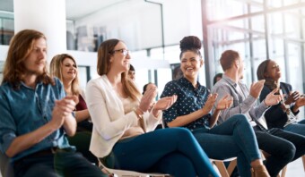 Un grupo de personas entrando en confianza aplaudiendo en un auditorio.