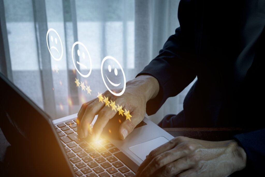 Un hombre está escribiendo en una computadora portátil con una cara sonriente.