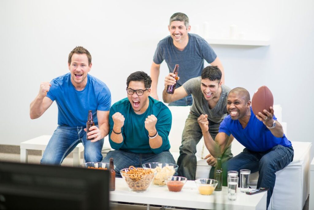 Un grupo de amigos viendo un partido de fútbol en un salón.