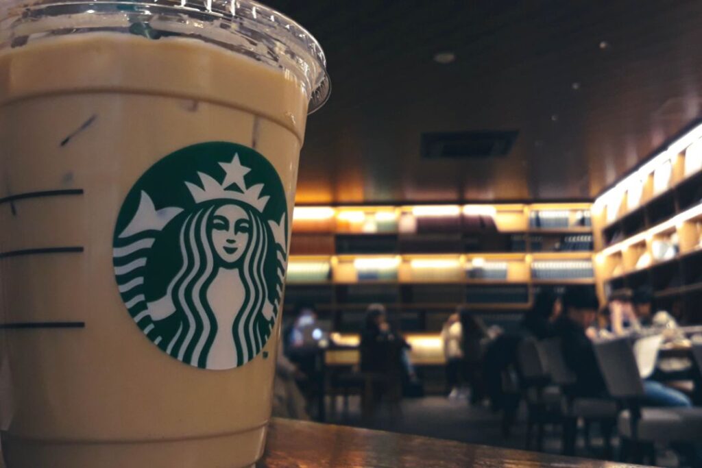 Una taza de café Starbucks encima de una mesa muestra el aspecto de marketing de experiencias.