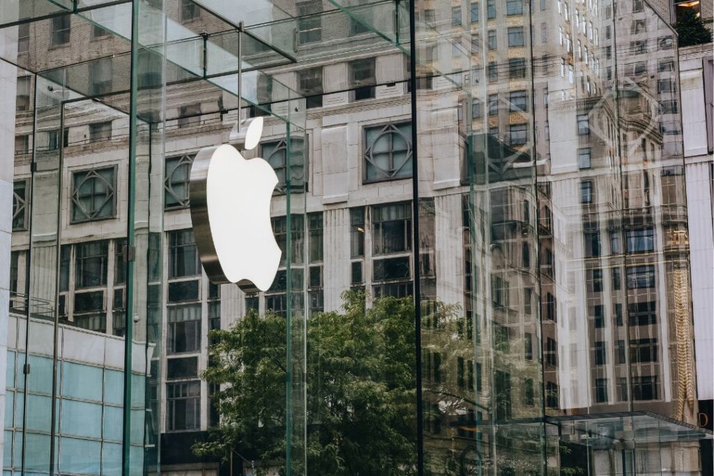 El logo de una manzana se refleja en el cristal de un edificio.