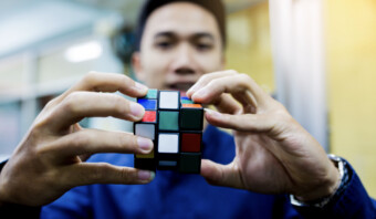Un hombre de la Generación X sosteniendo un cubo de Rubik.