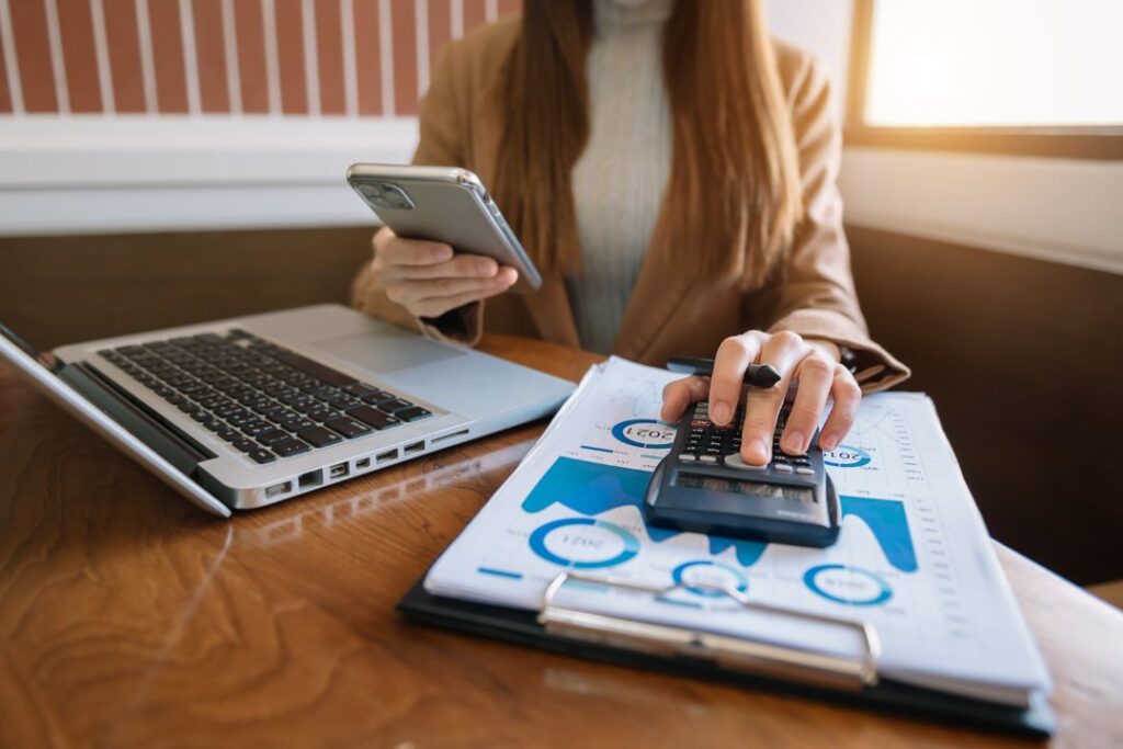 Una mujer usa un teléfono celular mientras está sentada en un escritorio durante la revolución digital.