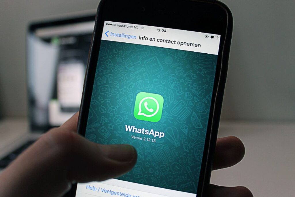 Una persona sostiene un teléfono con el logo de WhatsApp Business.