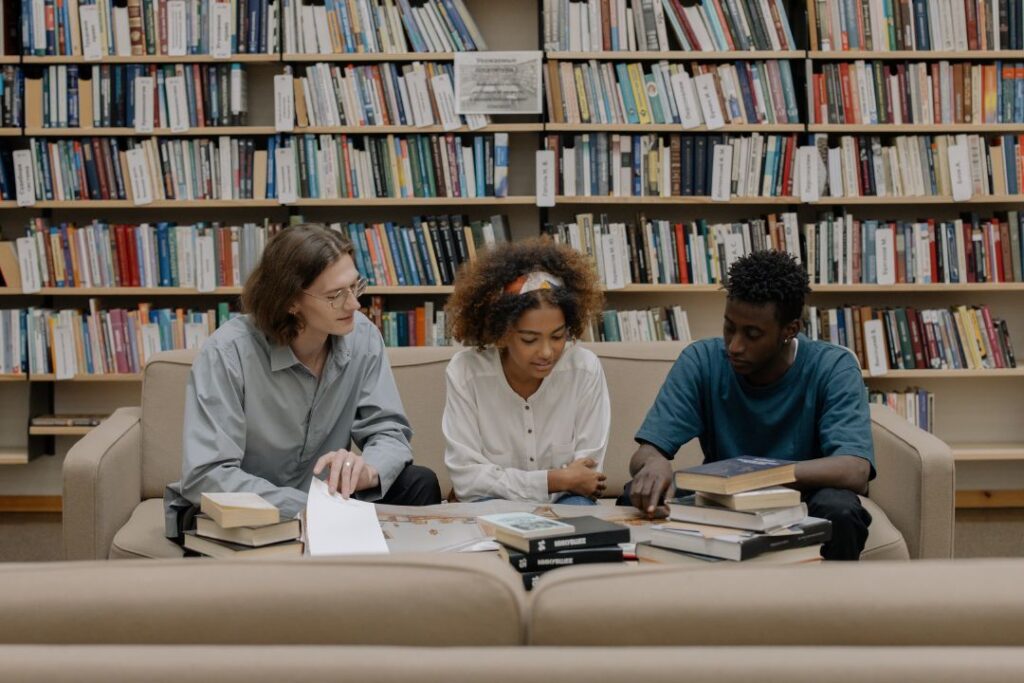 Un grupo de personas realizando estudios etnográficos en Mercadotecnia, sentadas en un sofá de una biblioteca.