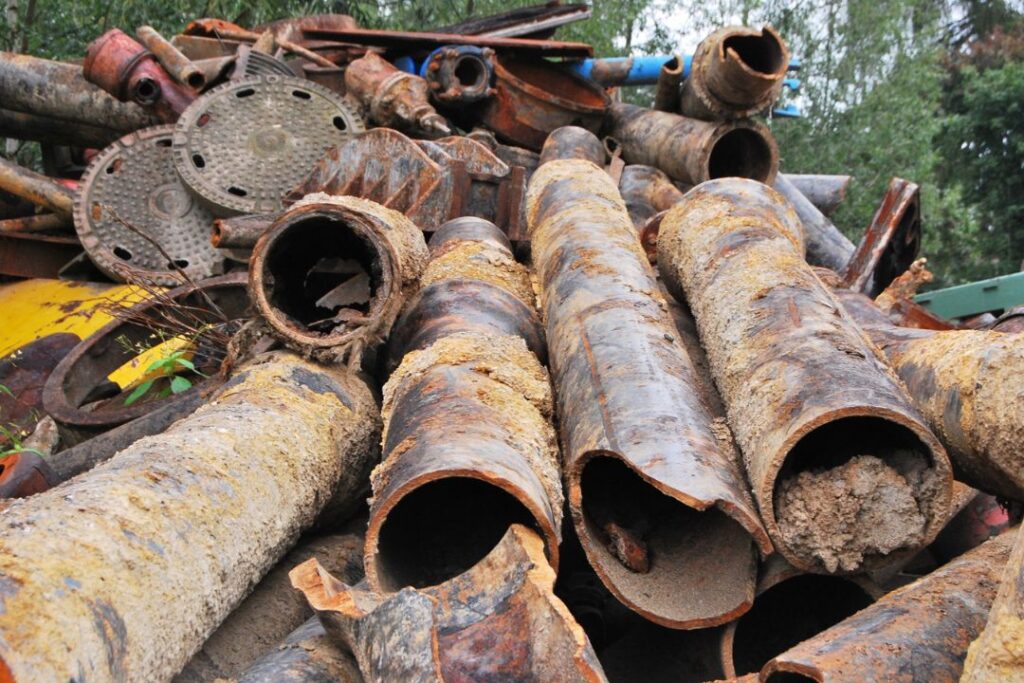 Un montón de tuberías oxidadas en una zona boscosa que muestra los usos y costumbres  locales.