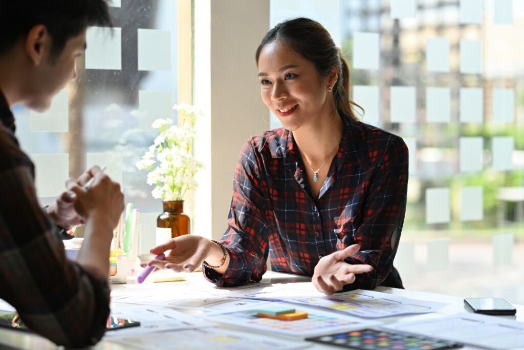 Dos personas participaron en una discusión sobre diseño UX en una mesa.