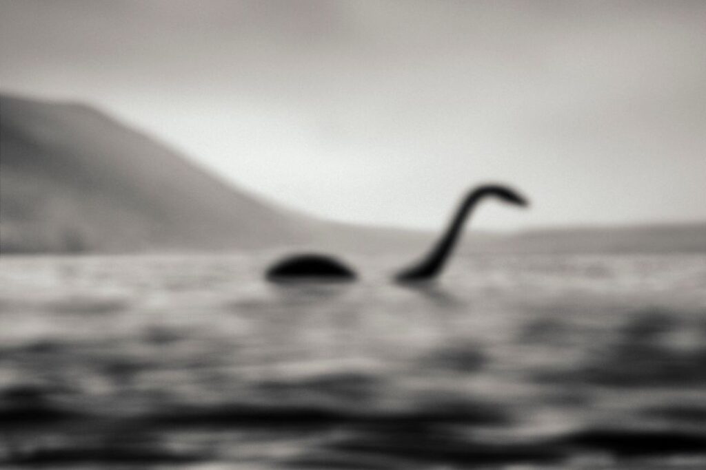 Una majestuosa fotografía en blanco y negro de unos monstruos en el Lago Ness