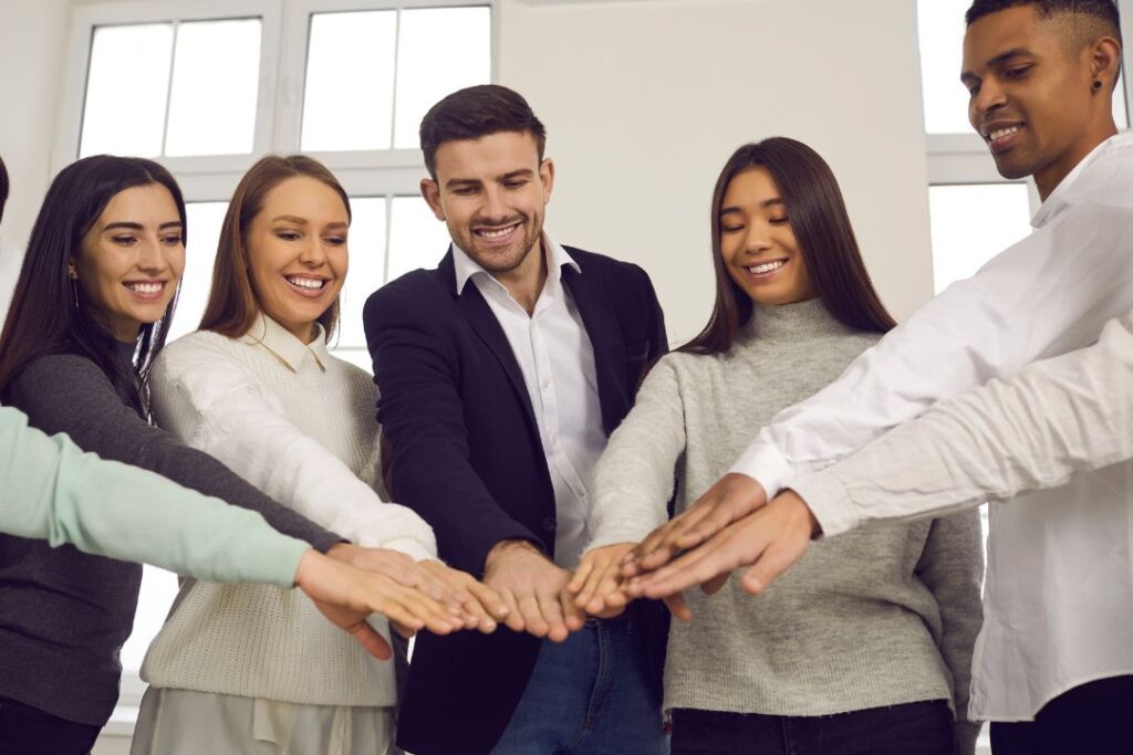 Un grupo de personas con talento en una empresa formando un círculo mientras se toman de la mano.