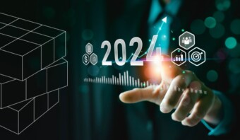 Un hombre con traje toca un cubo con la palabra 2020, destacando las últimas tendencias.