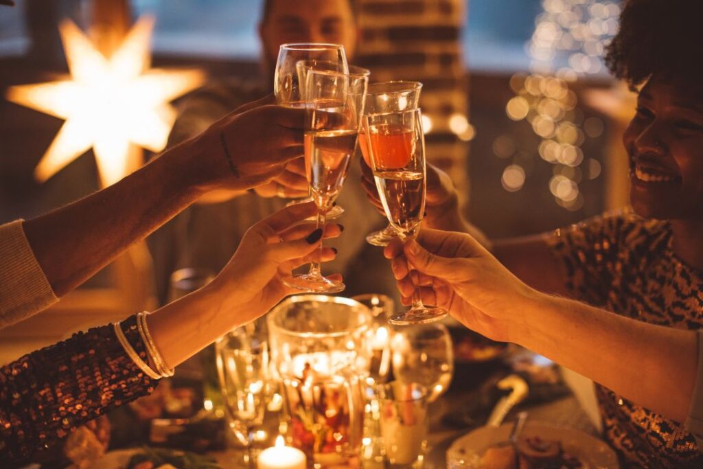 Un grupo de personas brindando con copas de champán en una mesa para celebrar propósitos.