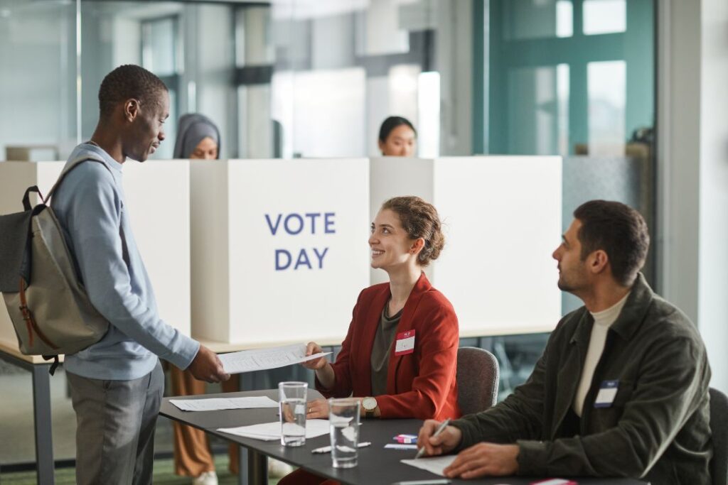 Un grupo de personas participando en una cabina de votación durante una campaña de marketing político.