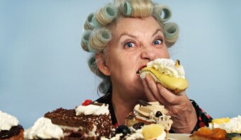 Una mujer mayor disfrutando de un plato de pasteles.