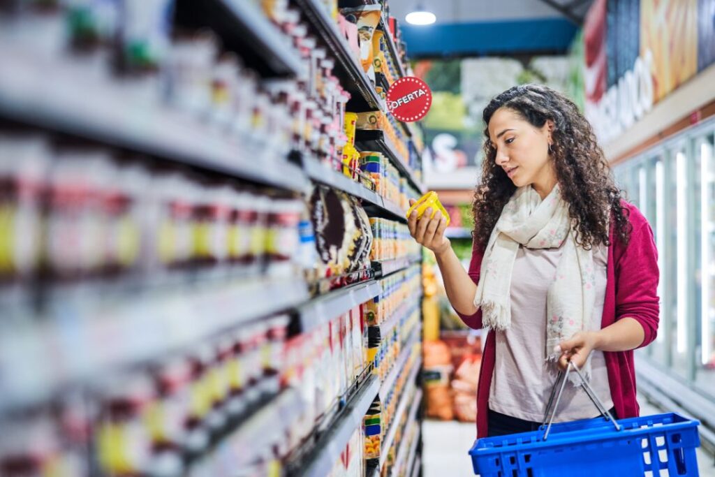 Una mujer está de compras en el pasillo de un supermercado del retail