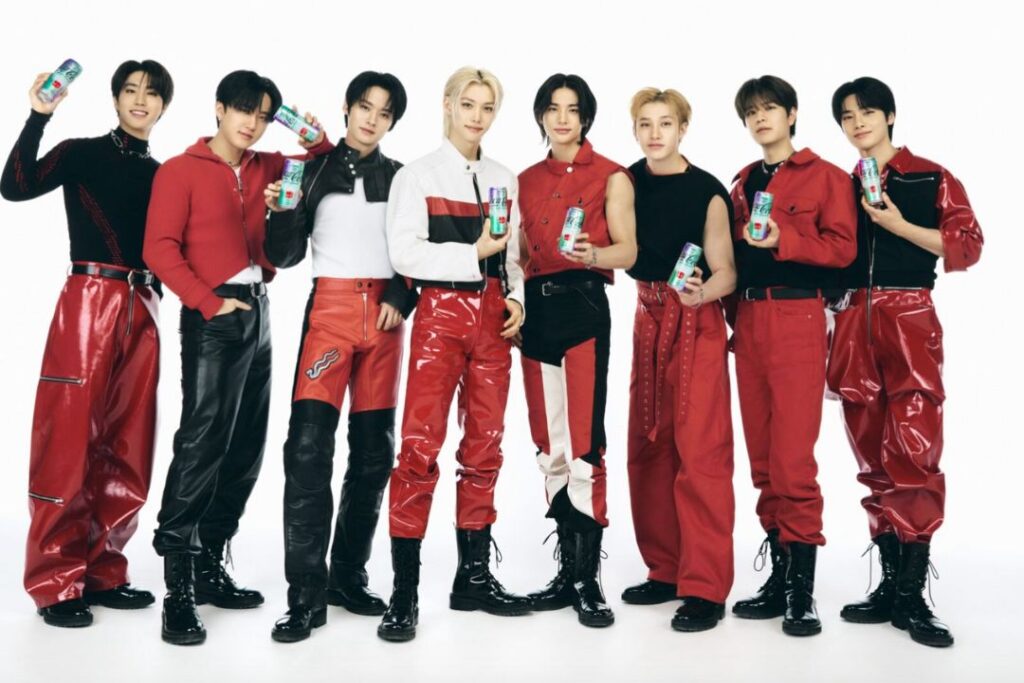 Un grupo de hombres vestidos de rojo posando para una foto en un evento de fandom de K-Pop  de Coca-Cola.