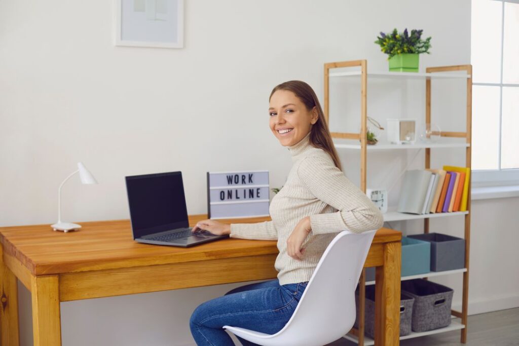 Descripción: Una mujer trabajando en un escritorio con una computadora portátil. (flexibilidad)