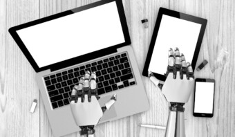 Manos robóticas escribiendo en una computadora portátil y usando una tableta, con un teléfono inteligente cerca que muestra IA en pagos, todo sobre una superficie de madera.