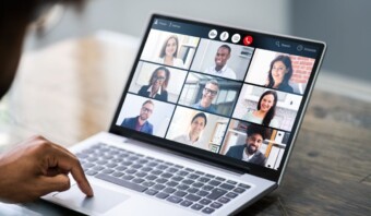 Una persona asiste a una videoconferencia en una computadora portátil, mostrando una cuadrícula de 10 participantes con sonrisas y expresiones neutrales, ejemplificando el espíritu vibrante de las comunidades en línea.