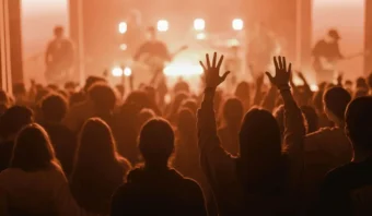 Mientras una cálida iluminación naranja baña la escena, un mar de manos se levanta al unísono, agarrando productos que reflejan el espíritu de su banda favorita, mientras la vibra electrizante del concierto llena el aire.