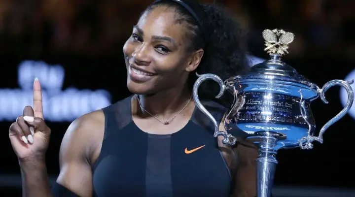 Un tenista sosteniendo un trofeo y sonriendo, con un dedo levantado mostrando el marketing deportivo femenino