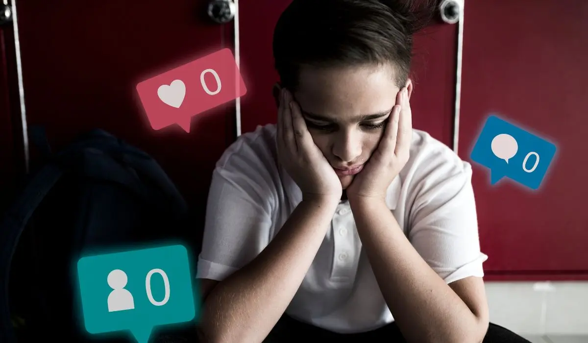 Un niño triste se sienta con la cabeza entre las manos, rodeado de íconos de redes sociales que muestran cero “me gusta”, comentarios y seguidores, frente a casilleros rojos.