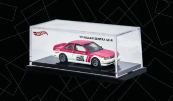 Un coche diecast Nissan Sentra SE-R del 91 de Hot Wheels presentado en una vitrina transparente con base negra y elegante rotulación blanca.