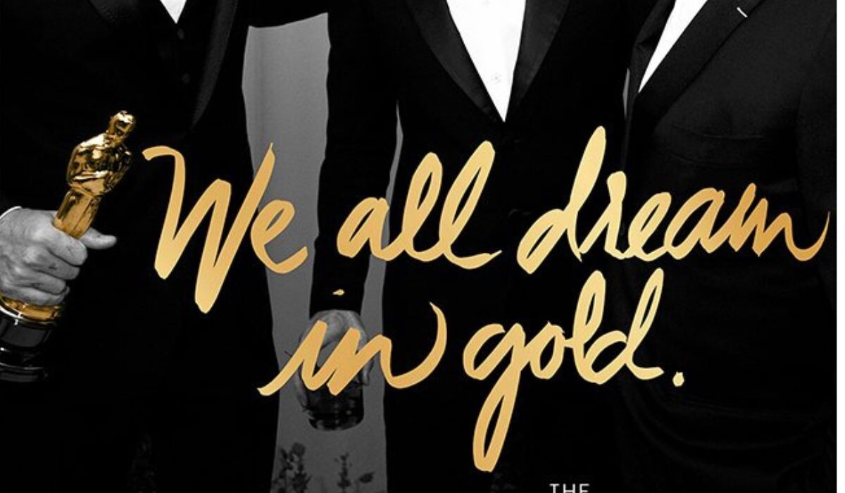 Tres personas con traje, una de ellas sosteniendo una estatua dorada. Sobre la imagen se lee: "Todos soñamos en oro", evocando el glamour de los Oscar 2016.