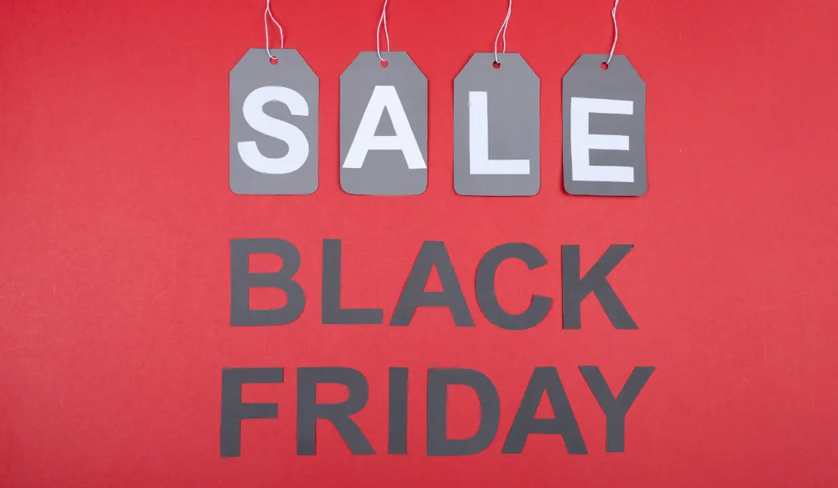 Las etiquetas de oferta de color gris cuelgan sobre un texto en negrita que dice "Viernes Negro" sobre un fondo rojo, capturando la emoción de las ofertas de El Buen Fin.