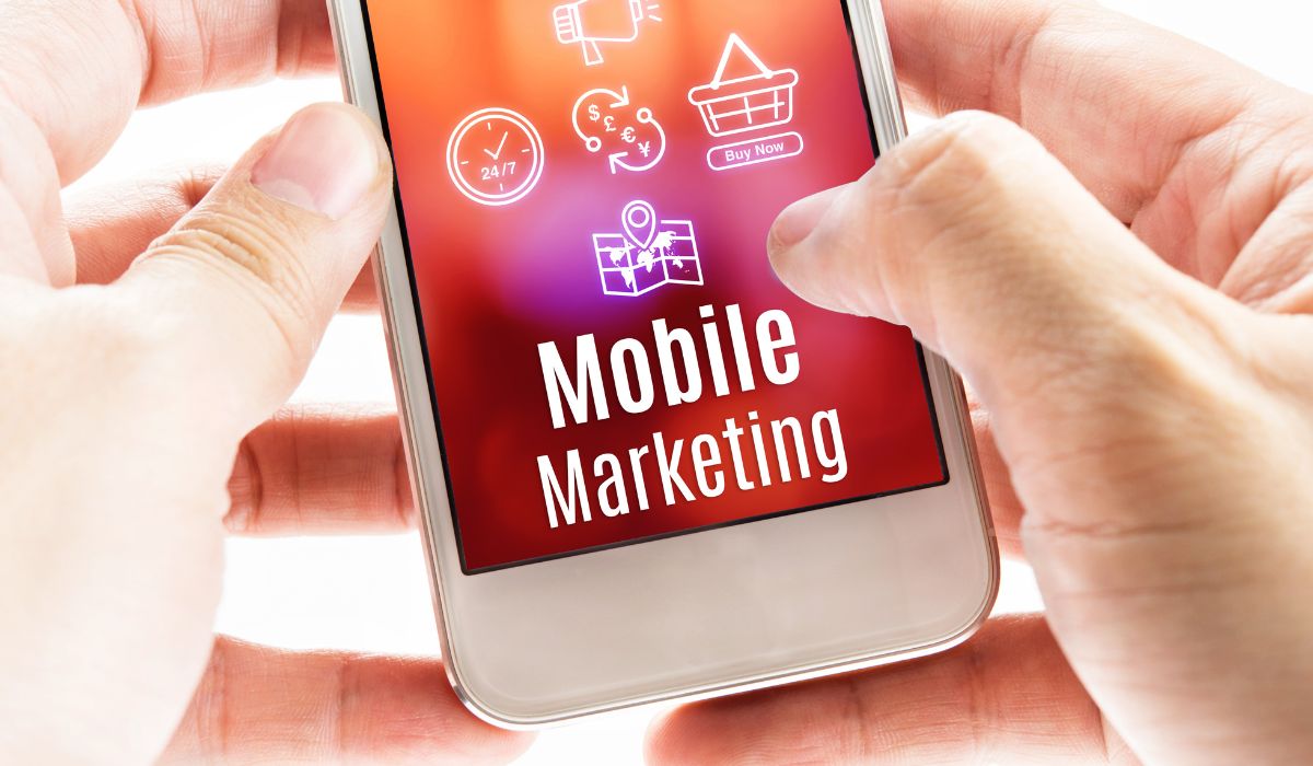 Una persona sosteniendo un teléfono inteligente con la palabra marketing de aplicaciones.