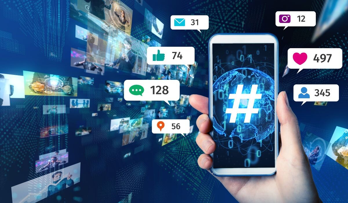 Una mano que sostiene un teléfono inteligente que muestra un símbolo de hashtag, rodeado de pantallas digitales flotantes que muestran varios íconos de redes sociales y números de participación.